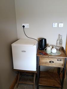 a white refrigerator sitting next to a wooden table at Liam's Cottage Bed and Breakfast in Lisdoonvarna