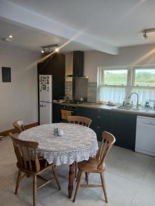 a kitchen with a table and chairs in a kitchen at Liam's Cottage Bed and Breakfast in Lisdoonvarna