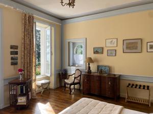a living room with a couch and a desk and a window at Manoir Mer & Pins in Fouesnant