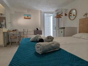 a hotel room with a bed with towels on it at NIKOLAS HOUSE CLOSE To TOWN in Mikonos