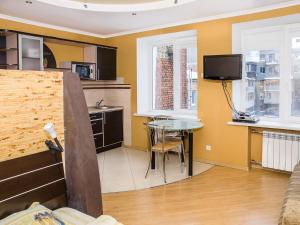 Il comprend un salon avec une table et une cuisine. dans l'établissement Central Studio Tatiana, à Kharkov