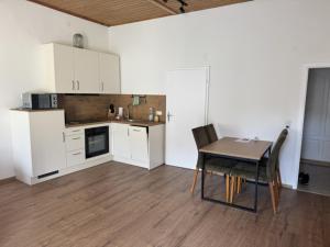 a kitchen with white cabinets and a table and a table and chairs at Kaiser von Österreich in Bad Aussee