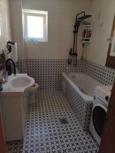 a bathroom with a sink and a tub and a toilet at doudou homestay in Veternik
