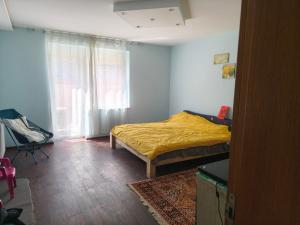 a bedroom with a bed with a yellow blanket on it at doudou homestay in Veternik
