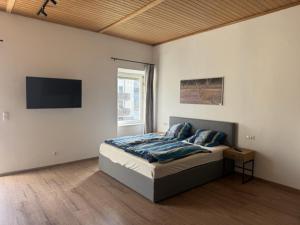 a bedroom with a bed and a flat screen tv at Kaiser von Österreich in Bad Aussee