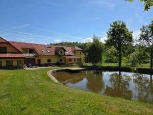 a house with a pond in the yard at Podveský mlýn in Tlumačov