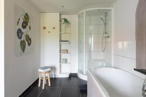 a bathroom with a tub and a shower and a stool at Gîte Athois la campagne in Ath +23 photos
