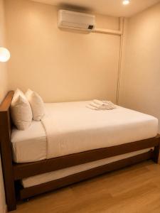 a small bedroom with a bed with a air conditioner at Cloud Nest House Betong in Betong