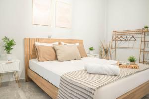 a bedroom with a white bed with a wooden headboard at Dafni Villa a place to visit by Rentado in Orné +53 photos
