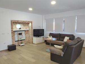 a living room with a couch and a tv at Alojamiento de Jorge in Herencia