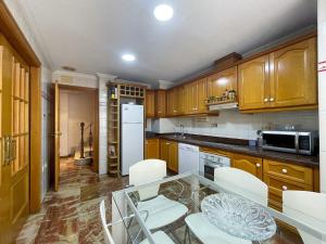 a kitchen with a glass table and white appliances at Dúplex 2 plantas en Centro histórico de Elche in Elche
