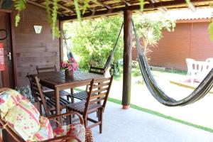 a porch with a hammock and a table and chairs at Green Mountain Pousada in Florianópolis