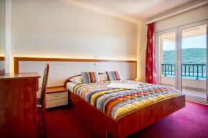 a bedroom with a bed and a desk and a window at Hotel Adria in Neum +115 photos