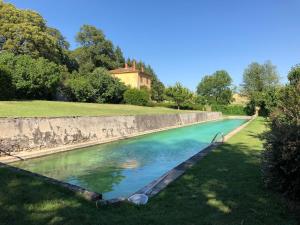 a pool of water next to a stone wall at Chateau de Barral - Piscine privée in Hauterives