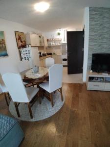 a kitchen and dining room with a table and white chairs at ODMOR PRESEKA - REST HOUSE PRESEKA in Plužine