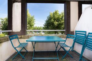 two chairs and a blue table on a balcony at Appartement 4p - piscine partagée in Arzon +12 photos