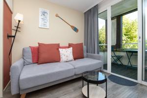 a living room with a couch and a table at Appartement 4p - piscine partagée in Arzon