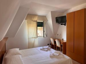 a bedroom with a bed and a table and a window at Albergo Lario in Gera Lario