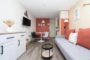 a living room with a couch and a table at Appartement 4p - piscine partagée in Arzon