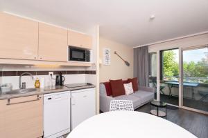a kitchen and a living room with a couch at Appartement 4p - piscine partagée in Arzon