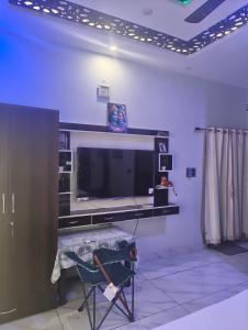 a living room with a flat screen tv and a desk at Rawat ji Homestay in Rāmnagar