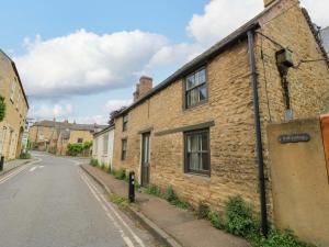 an old brick building on the side of a street at Well Cottage in Chipping Norton