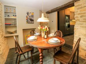 a kitchen and dining room with a wooden table and chairs at Well Cottage in Chipping Norton