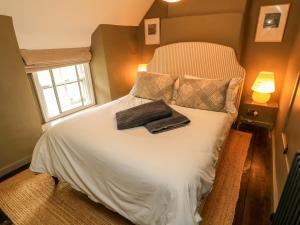 a bed with two towels on it in a bedroom at Well Cottage in Chipping Norton