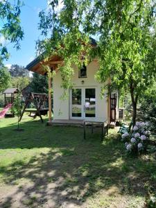 a house with a playground in the yard at Domek Akacja in Oblassy