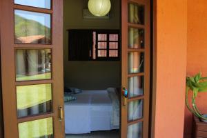 a door leading to a bedroom with a bed at Green Mountain Pousada in Florianópolis