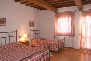 ヴォルテッラにあるLa Colombainaのベッドルーム1室(ベッド2台付)、窓(カーテン付)