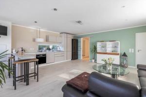 a kitchen and living room with a couch and a table at Uhse Ferienwohnung Delux mit Loft in Heide