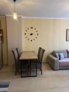 a living room with a table and a clock on the wall at Sea View Marjana Apartment in Skataj +1 photo