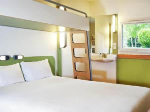 a bedroom with a bed and a sink at ibis budget Berlin Ost in Berlin +24 photos