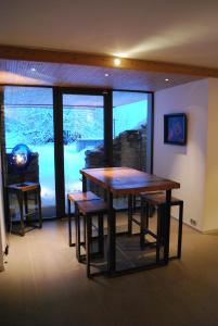 d'une salle à manger avec une table, des chaises et une fenêtre. dans l'établissement Mineral Lodge & Spa, à Villaroger