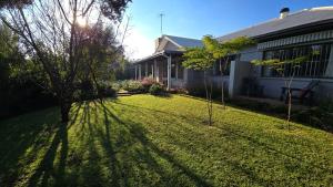 a yard with trees and a house at Amourette's Rose Cottage in Centurion