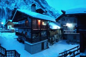 a ski lodge in the snow at night at Maison Carré in Rhêmes-Notre-Dame