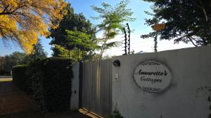 a sign on a wall next to a fence at Amourette's Rose Cottage in Centurion