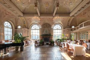 a dining room with tables and chairs and a fireplace at QC Grand Hotel Bagni Nuovi in Bormio +57 photos
