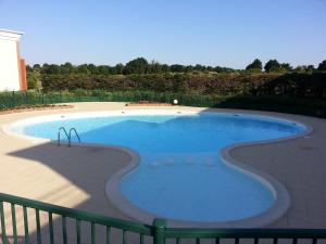 a large swimming pool in a yard with a fence at Maison proche Golf plage et piscine à Pornic in Pornic +13 photos