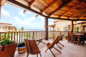 a patio with chairs and a table on a balcony at Indigo Belize Beach 2C in San Pedro