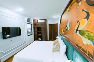a bedroom with a bed and a painting on the wall at OCEAN HOTEL Ninh Binh - Near Trang An & Hoa Lư Old Town in Kỳ Vĩ