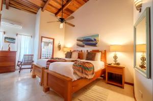 a bedroom with two beds and a ceiling fan at Indigo Belize Beach 2C in San Pedro
