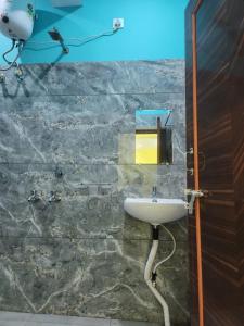 a bathroom with a sink on a stone wall at Hotel Navin Palace Pirpainti in Bhāgalpur