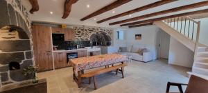 a kitchen and living room with a table in a room at Gîte Le Cheix d'Arches in Arches