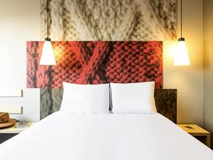 a bedroom with a large bed with two white pillows at Ibis Mexico Tlalnepantla in Mexico City