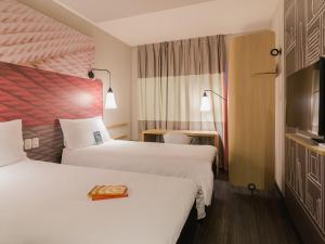 a hotel room with two beds and a television at ibis Erechim in Erechim +147 photos