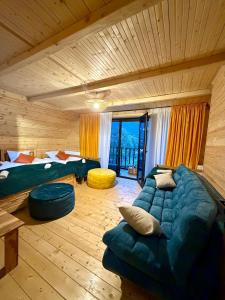a room with two beds and a couch in a room at Grand Hills Kazbegi in (( Gergeti ))