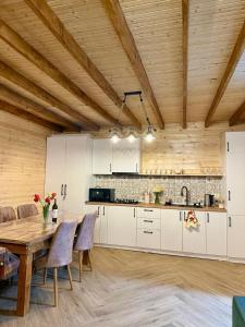 a kitchen with white cabinets and a wooden ceiling at Grand Hills Kazbegi in (( Gergeti ))