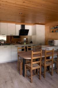 a kitchen with a wooden table and wooden ceiling at Chardonneret 3 in La Clusaz +18 photos